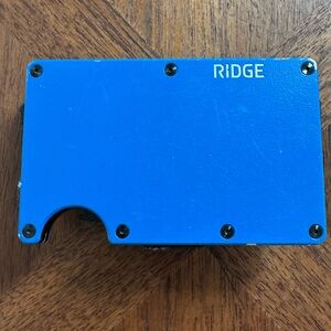 Ridge Vibrant Blue Metal Wallet with AirTag accessory.